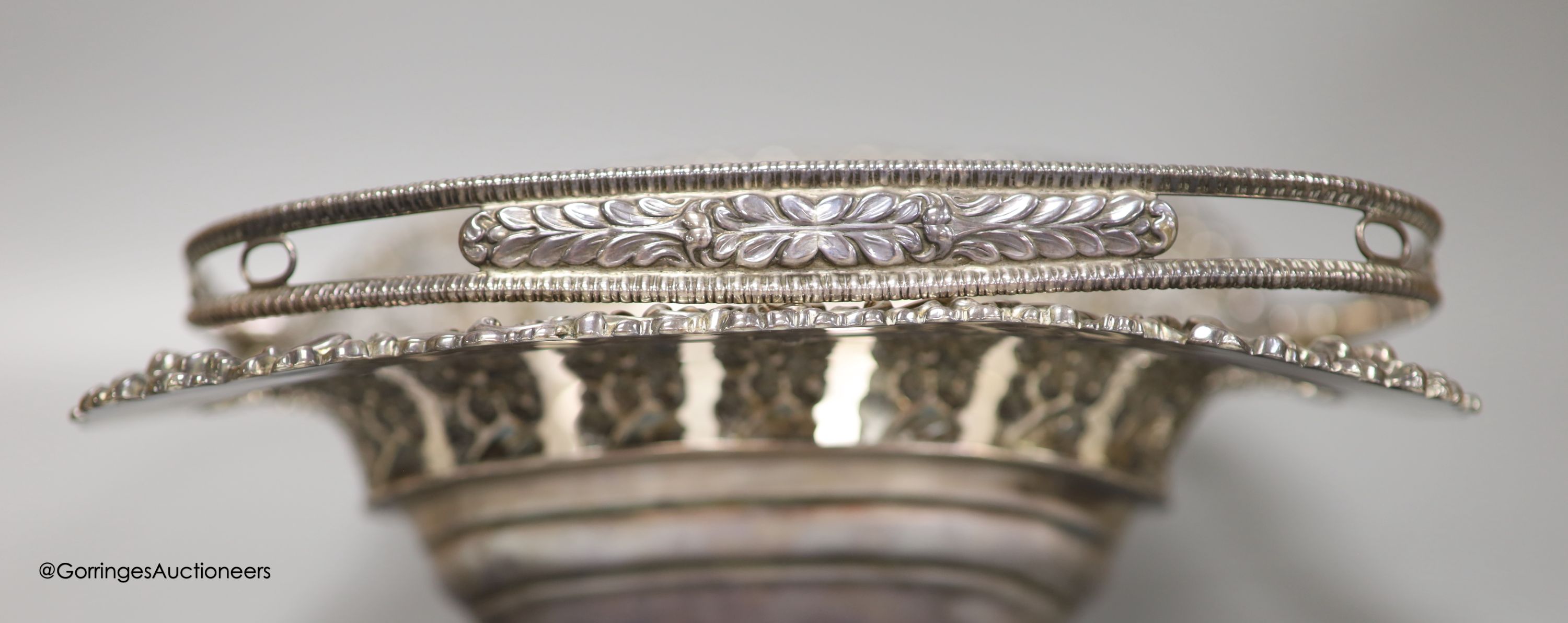 A George III silver swing-handled cake basket with cast and embossed foliate decoration, 28.83oz